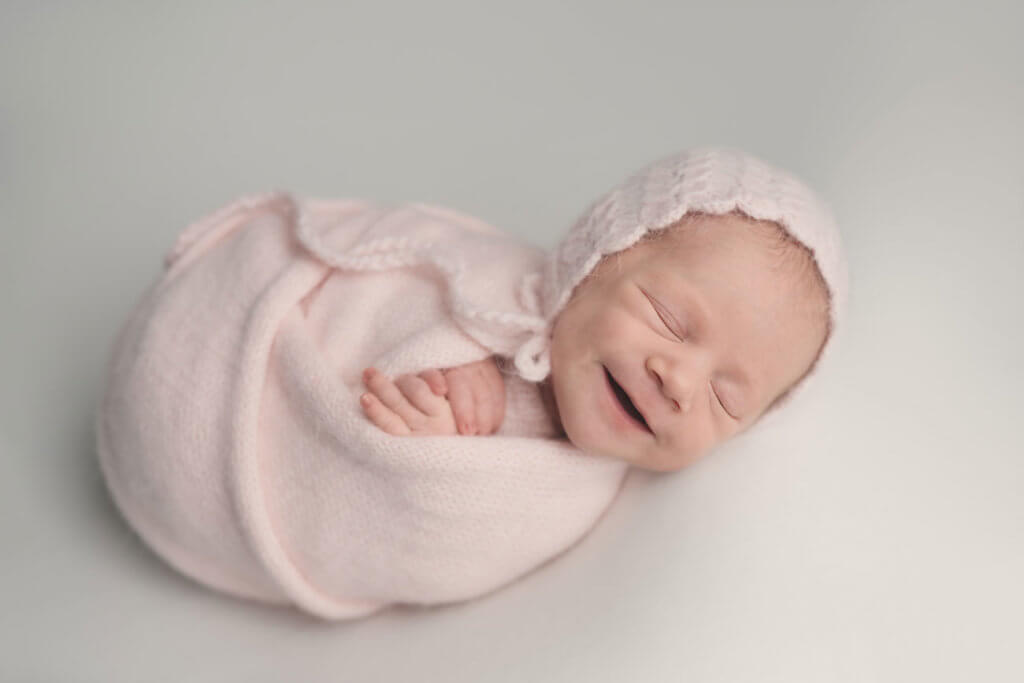 Neugeborenesbaby lächelt Bild